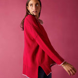 Raspberry pink knit V-neck sweater with a ribbed hem and white trim.