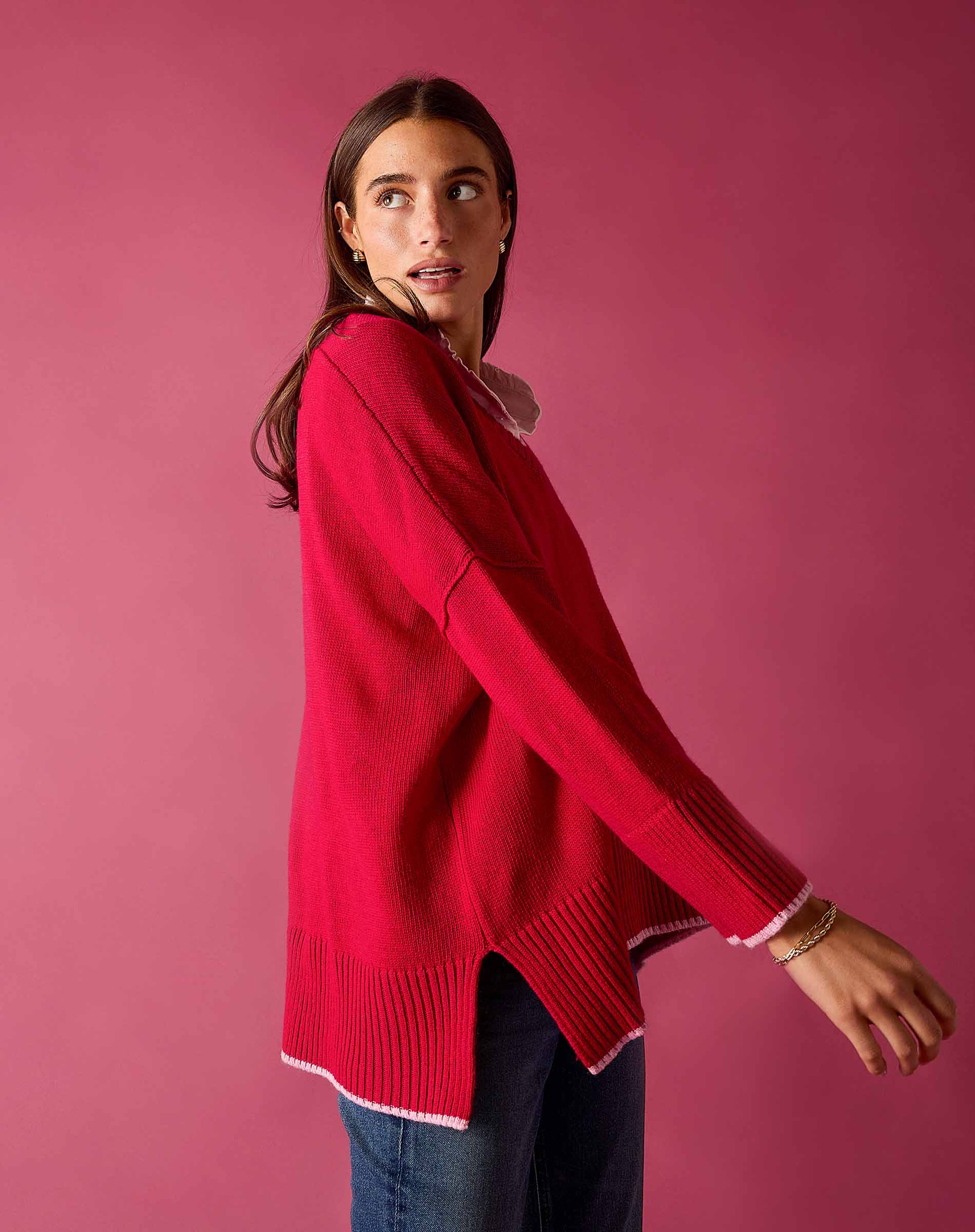 Raspberry pink knit V-neck sweater with a ribbed hem and white trim.