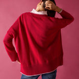 Raspberry pink V-neck knit sweater with a ribbed hem and white undershirt.
