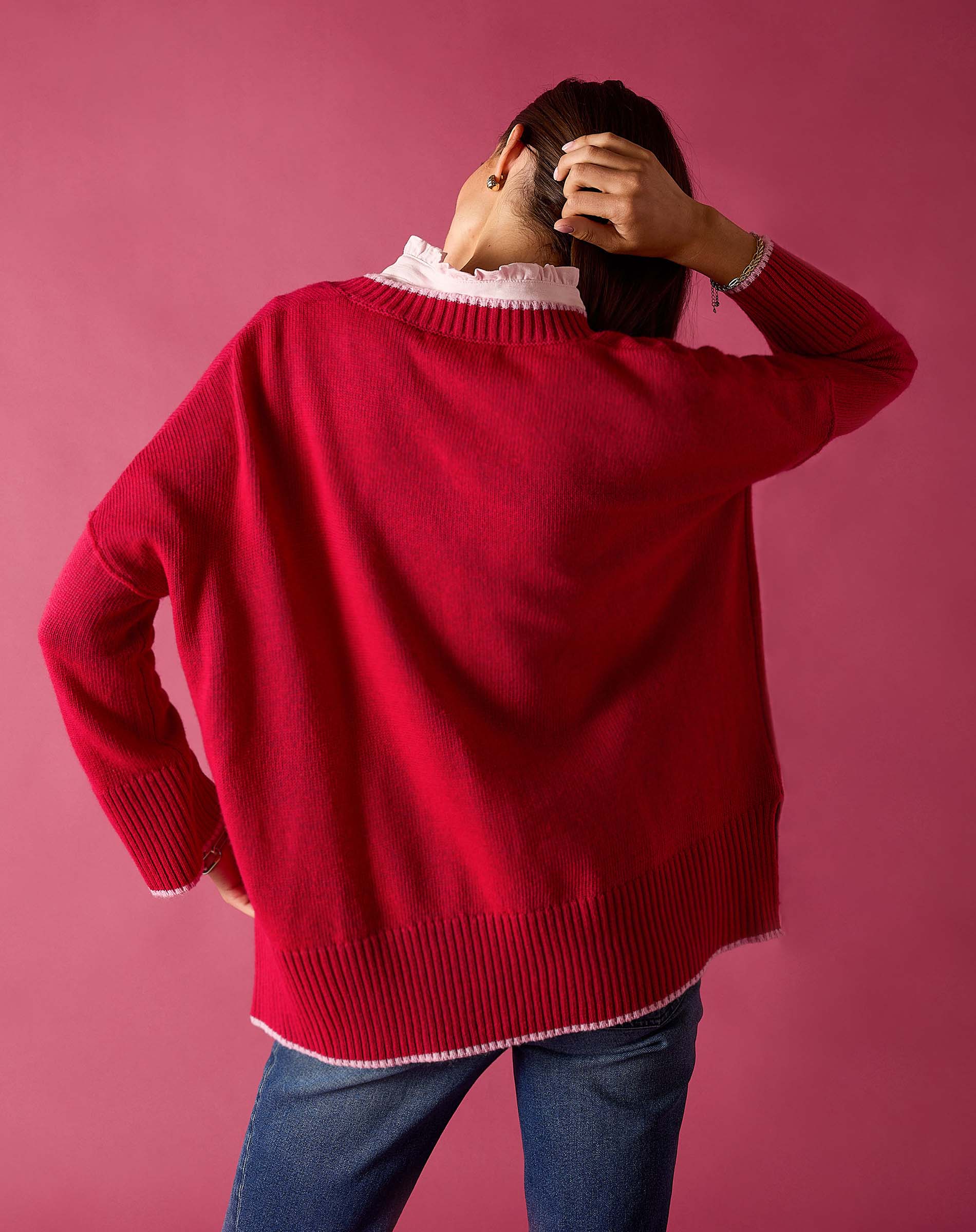 Raspberry pink V-neck knit sweater with a ribbed hem and white undershirt.