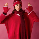 Raspberry pink v-neck knit sweater with white trim and a matching pom-pom beanie.