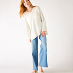 woman wearing mersea montauk v-neck sweater with wide sleeves in cream color