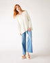 woman wearing mersea montauk v-neck sweater with wide sleeves in cream color