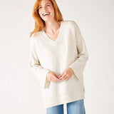 woman wearing mersea montauk v-neck sweater with wide sleeves in cream color