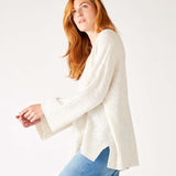 profile of woman wearing mersea montauk v-neck sweater with wide sleeves in cream color