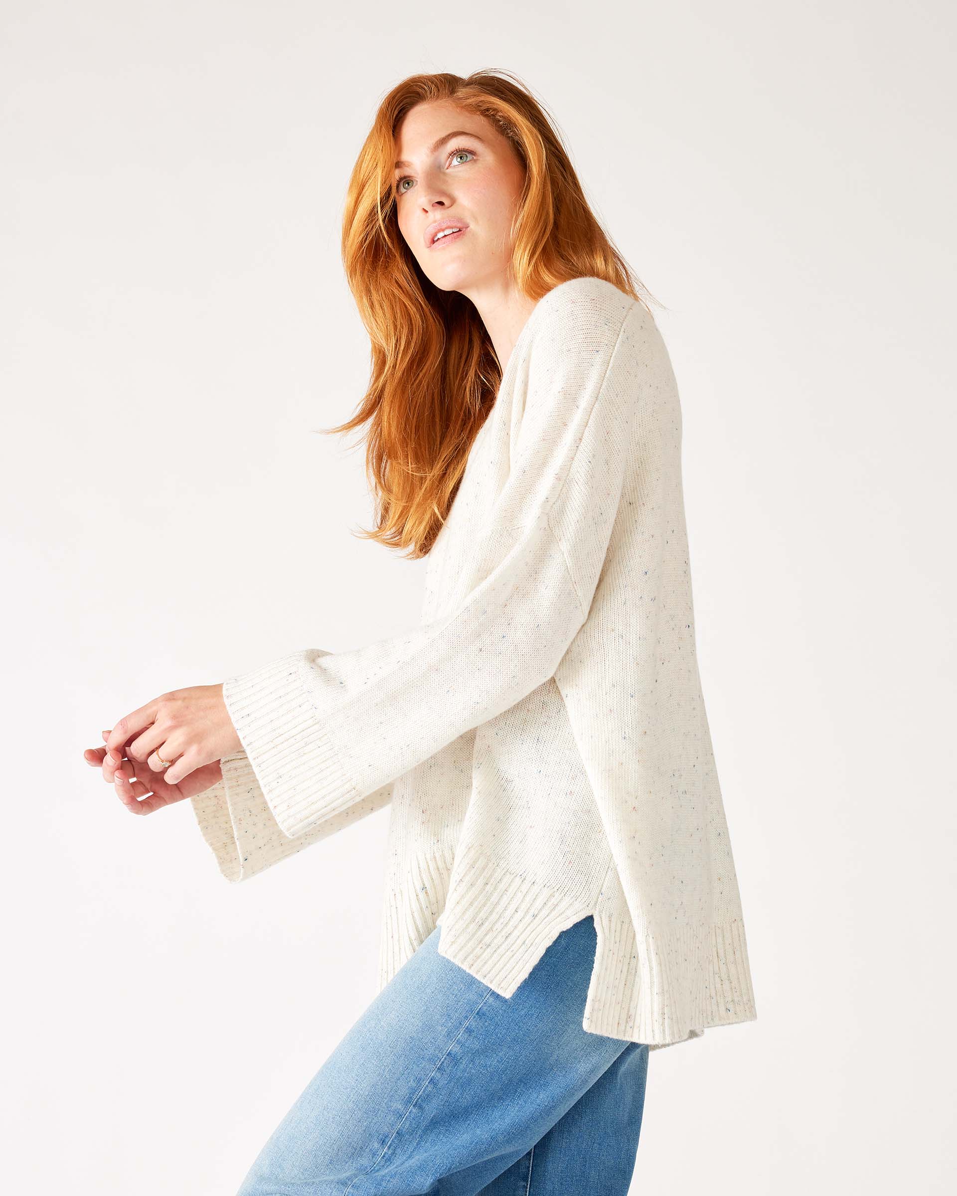 profile of woman wearing mersea montauk v-neck sweater with wide sleeves in cream color