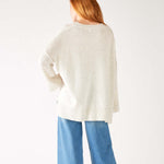 rearview of woman wearing mersea montauk v-neck sweater with wide sleeves in cream color