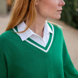 Woman wearing a green sweater with a white collar outdoors