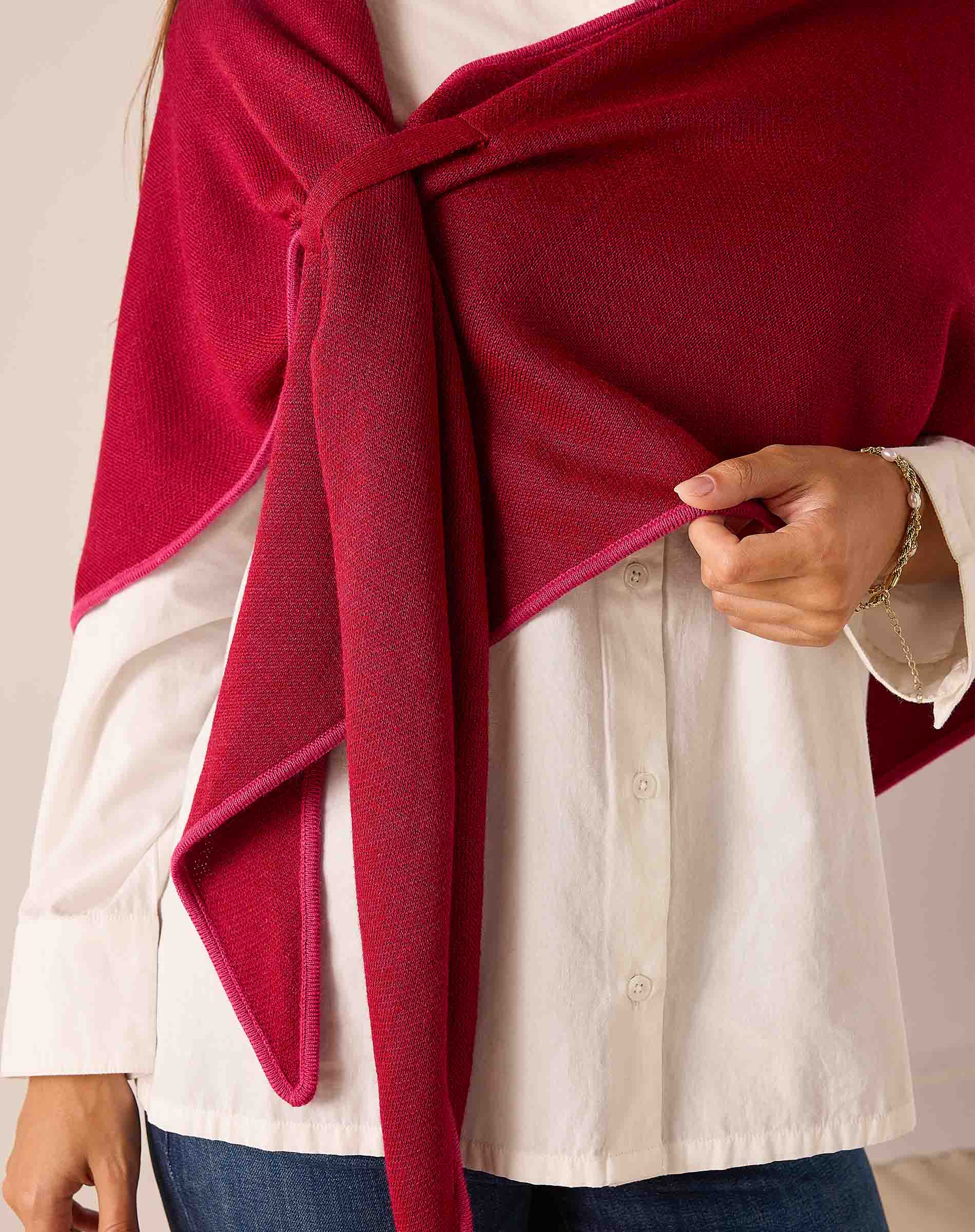 Wine pinkberry oversized knit scarf draped over a white linen shirt.