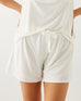 female wearing white pajama shorts and matching top on a white background