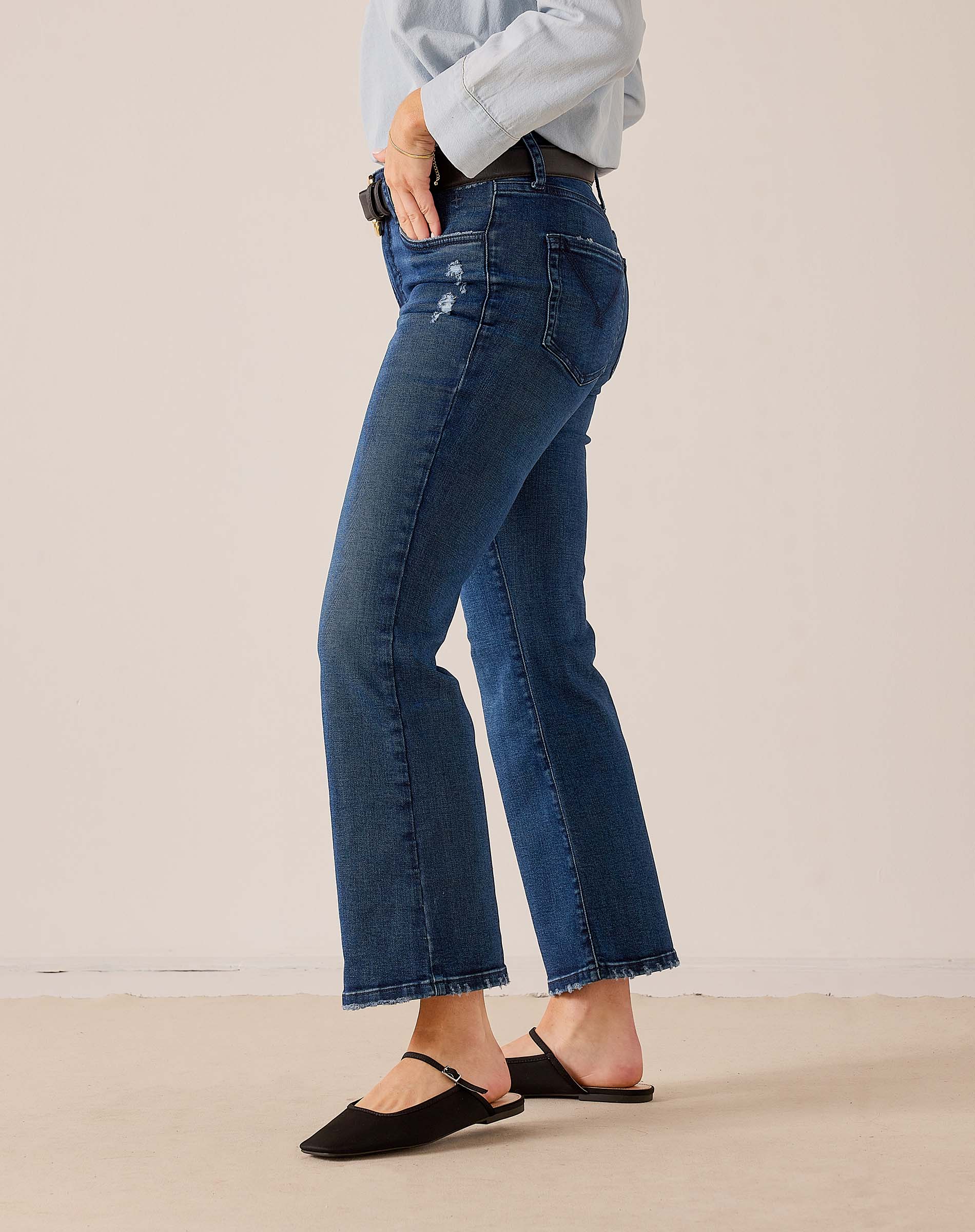 Medium wash blue denim wide-leg jeans featuring a relaxed fit and distressed detailing