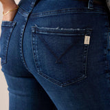 Dark indigo denim jeans featuring a back pocket with a distinctive embroidered 'V' stitch and branded tag.