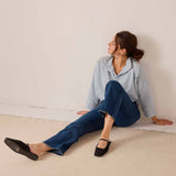 Light blue button-down shirt and dark wash denim jeans styled with black mules.