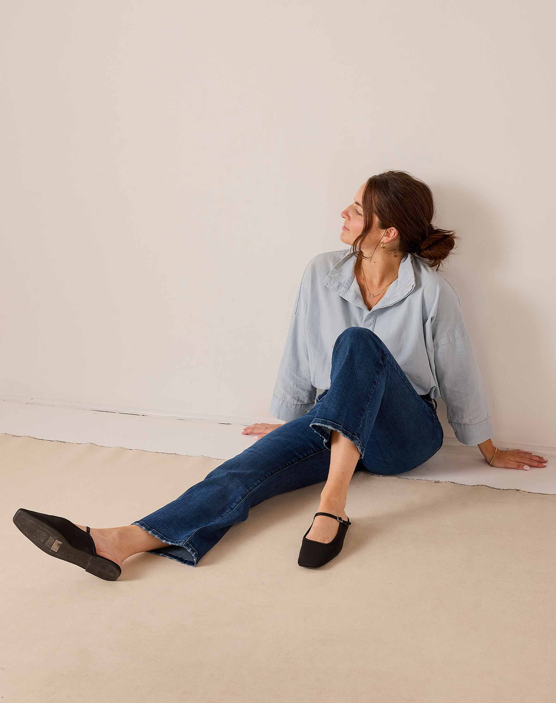 Light blue button-down shirt and dark wash denim jeans styled with black mules.