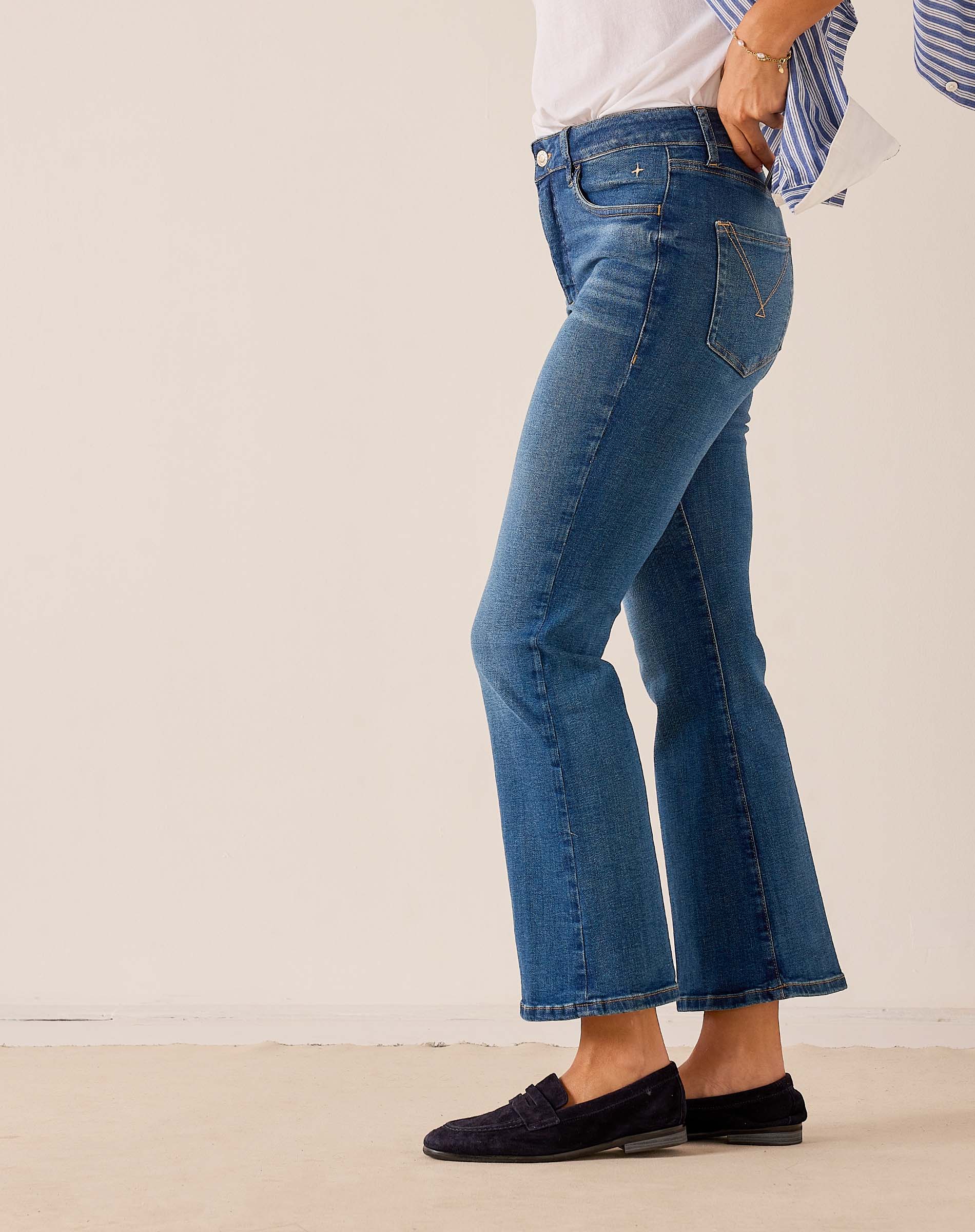 Medium blue flared denim jeans with frayed hems.