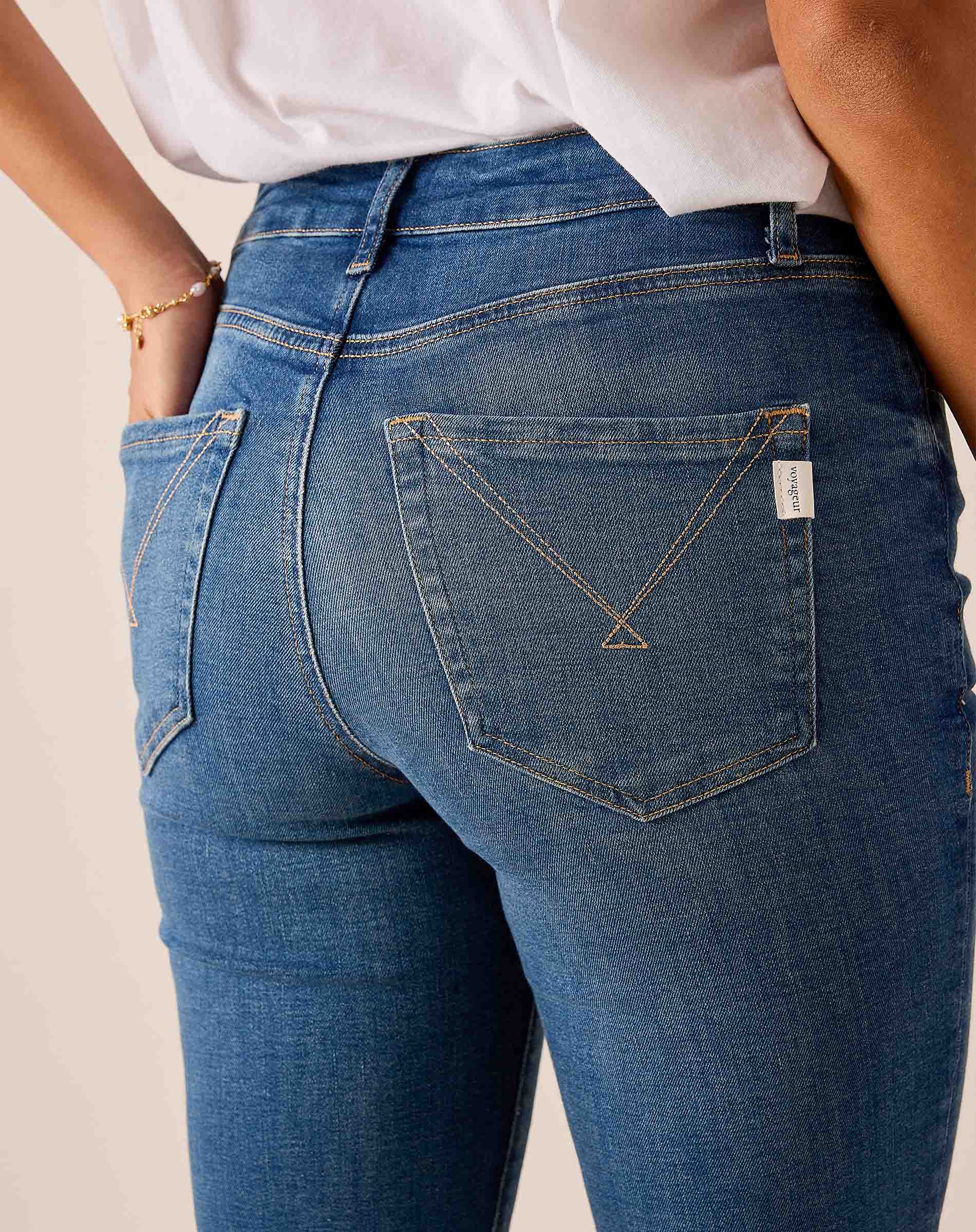 Blue denim jeans featuring back pocket detailing and a stitched western-style yoke.