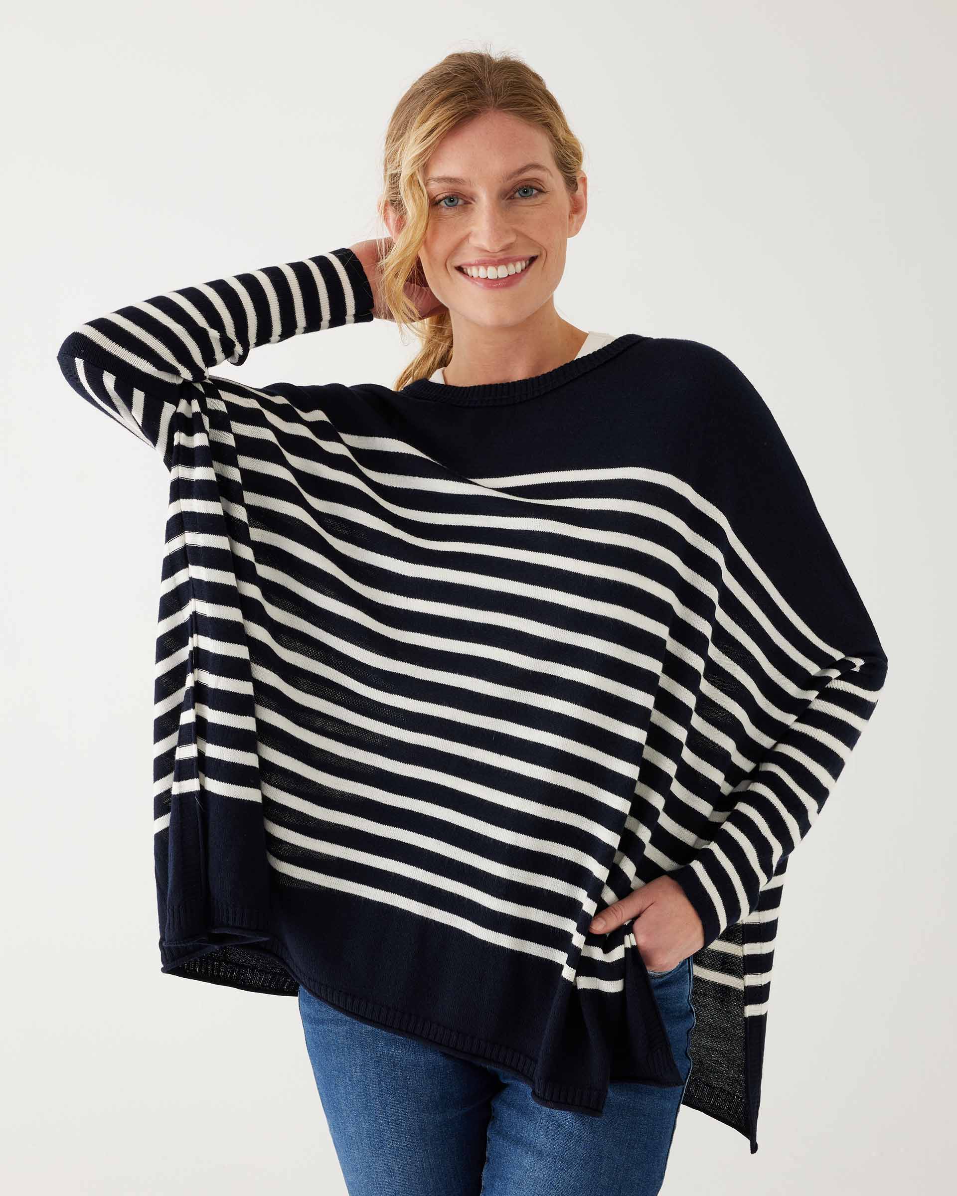 female wearing navy and white striped sweater with blue jeans on a white background