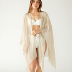 woman wearing lightweight mersea nellie wrap in neutral moonstone color draped around shoulders and arms