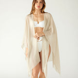 woman wearing lightweight mersea nellie wrap in neutral moonstone color draped around shoulders and arms