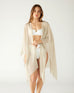 woman wearing lightweight mersea nellie wrap in neutral moonstone color draped around shoulders and arms