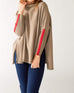 woman wearing mersea newport sweater in driftwood brown with red accent stripe down lower sleeve with a split front turtleneck and ribbed sleeves