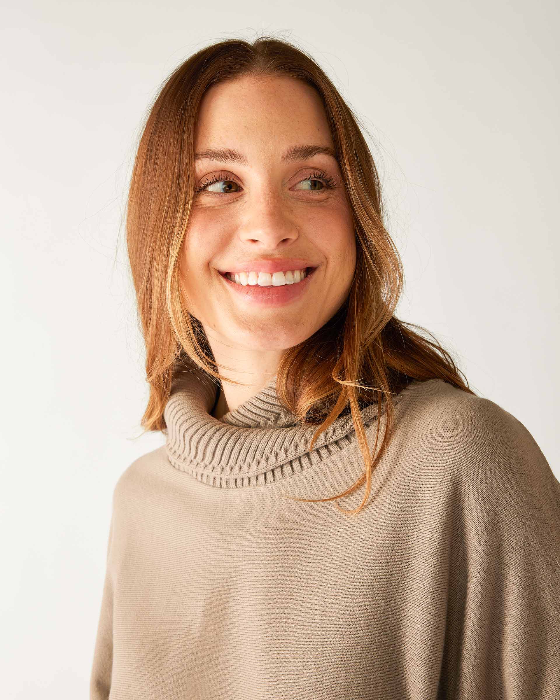 closeup of collar on woman wearing mersea newport sweater in driftwood brown with red accent stripe down lower sleeve with a split front turtleneck and ribbed sleeves