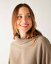 closeup of collar on woman wearing mersea newport sweater in driftwood brown with red accent stripe down lower sleeve with a split front turtleneck and ribbed sleeves