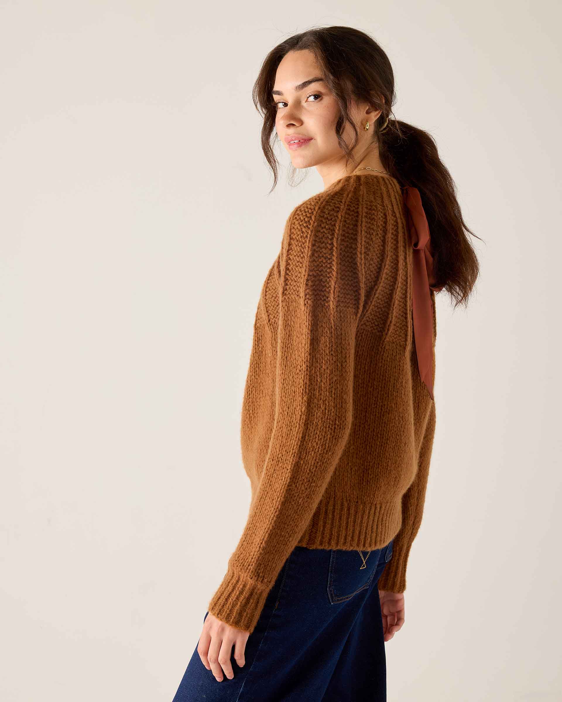 Cinder ribbed knit sweater featuring a wide ribbed texture and a largeer back ribbon detail.