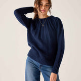 Women's travel-friendly navy blue ribbed knit sweater with long sleeves and a textured finish.