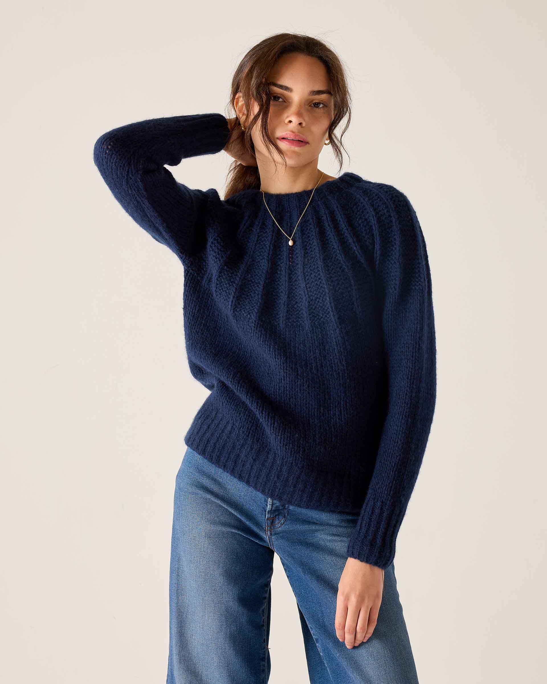 Women's travel-friendly navy blue ribbed knit sweater with long sleeves and a textured finish.
