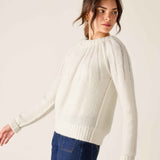 White knit sweater with a pleated front and ribbed cuffs.