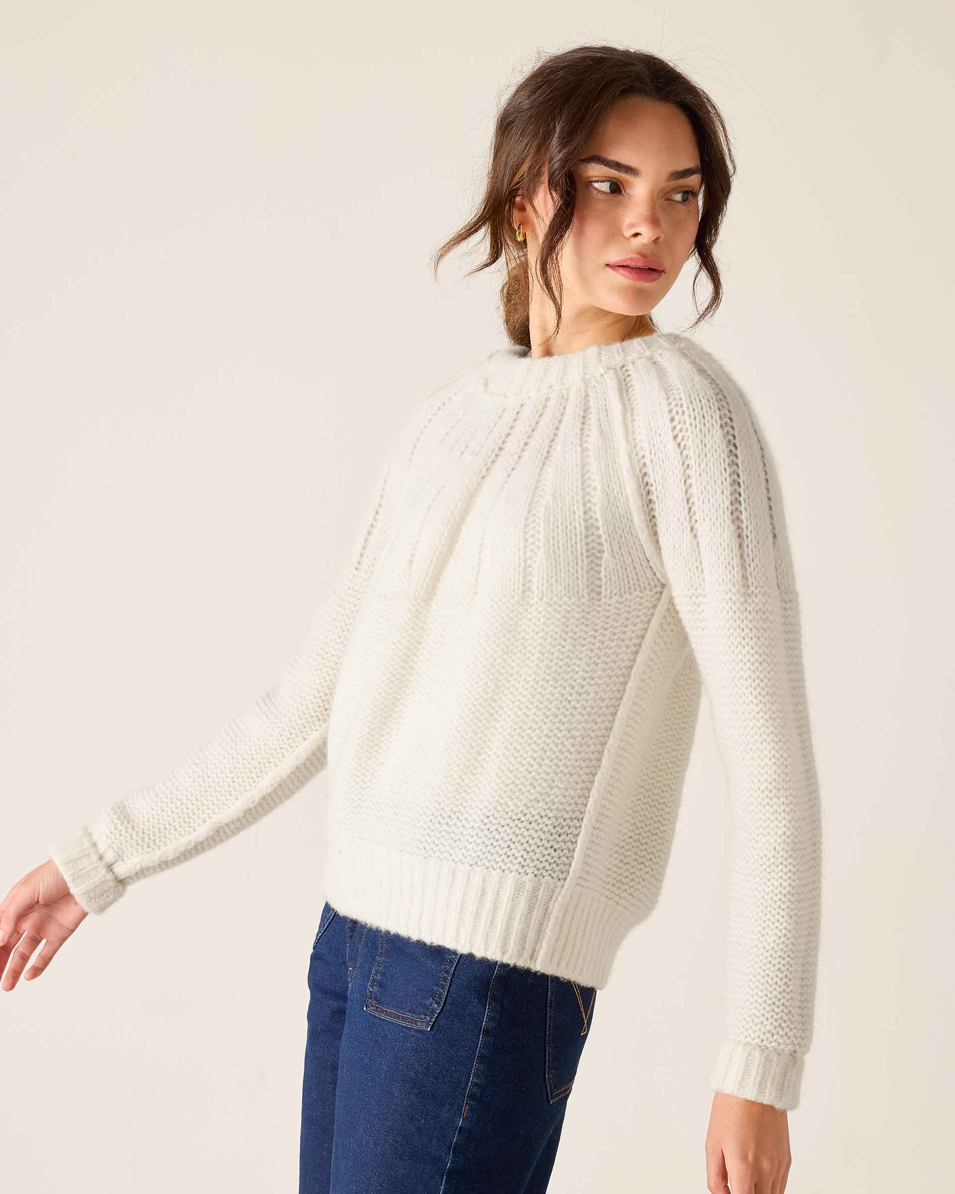 White knit sweater with a pleated front and ribbed cuffs.