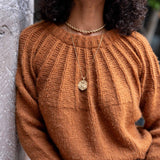 Ladies' travel-ready cinder orange ribbed knit sweater with a textured front panel.