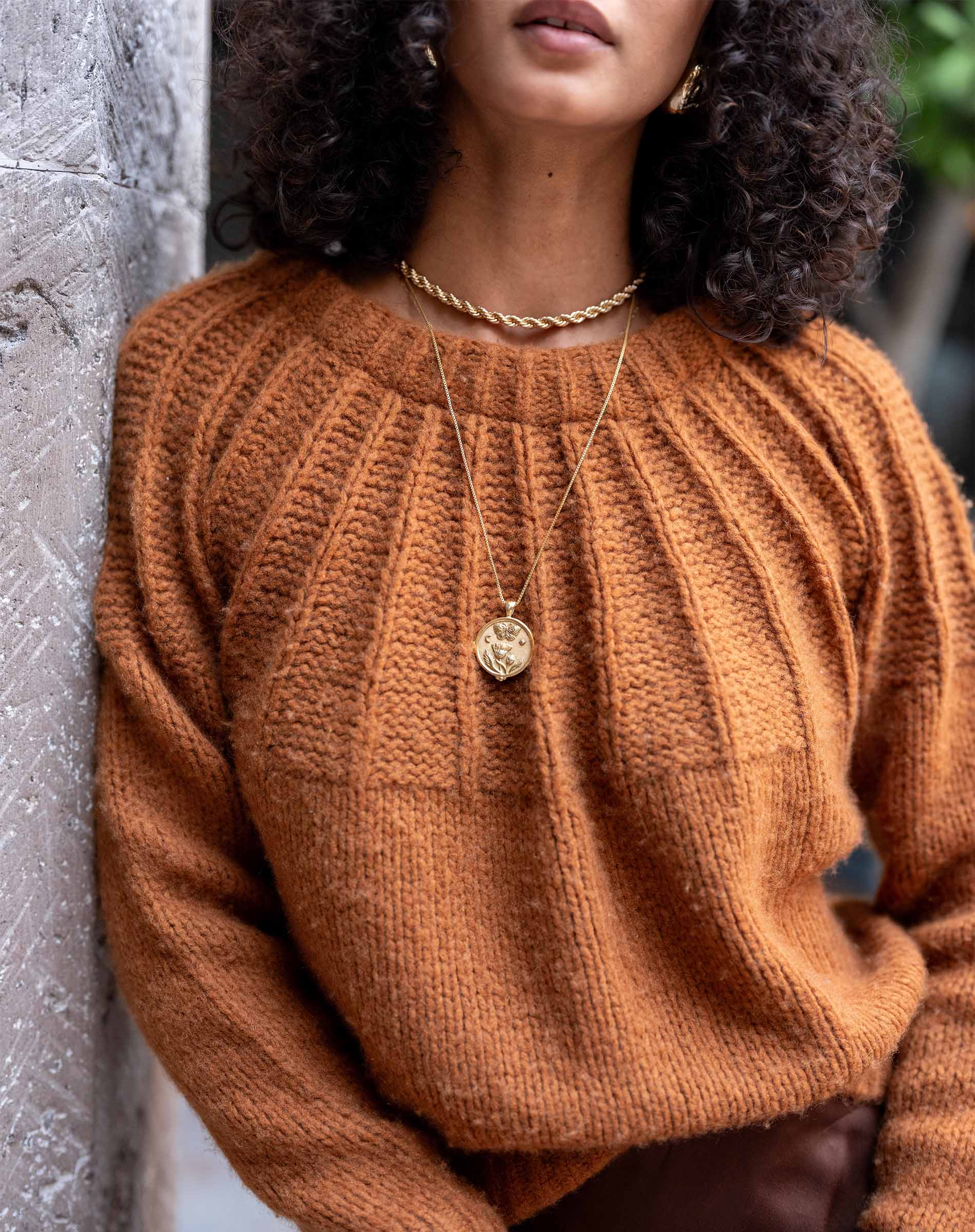 Ladies' travel-ready cinder orange ribbed knit sweater with a textured front panel.
