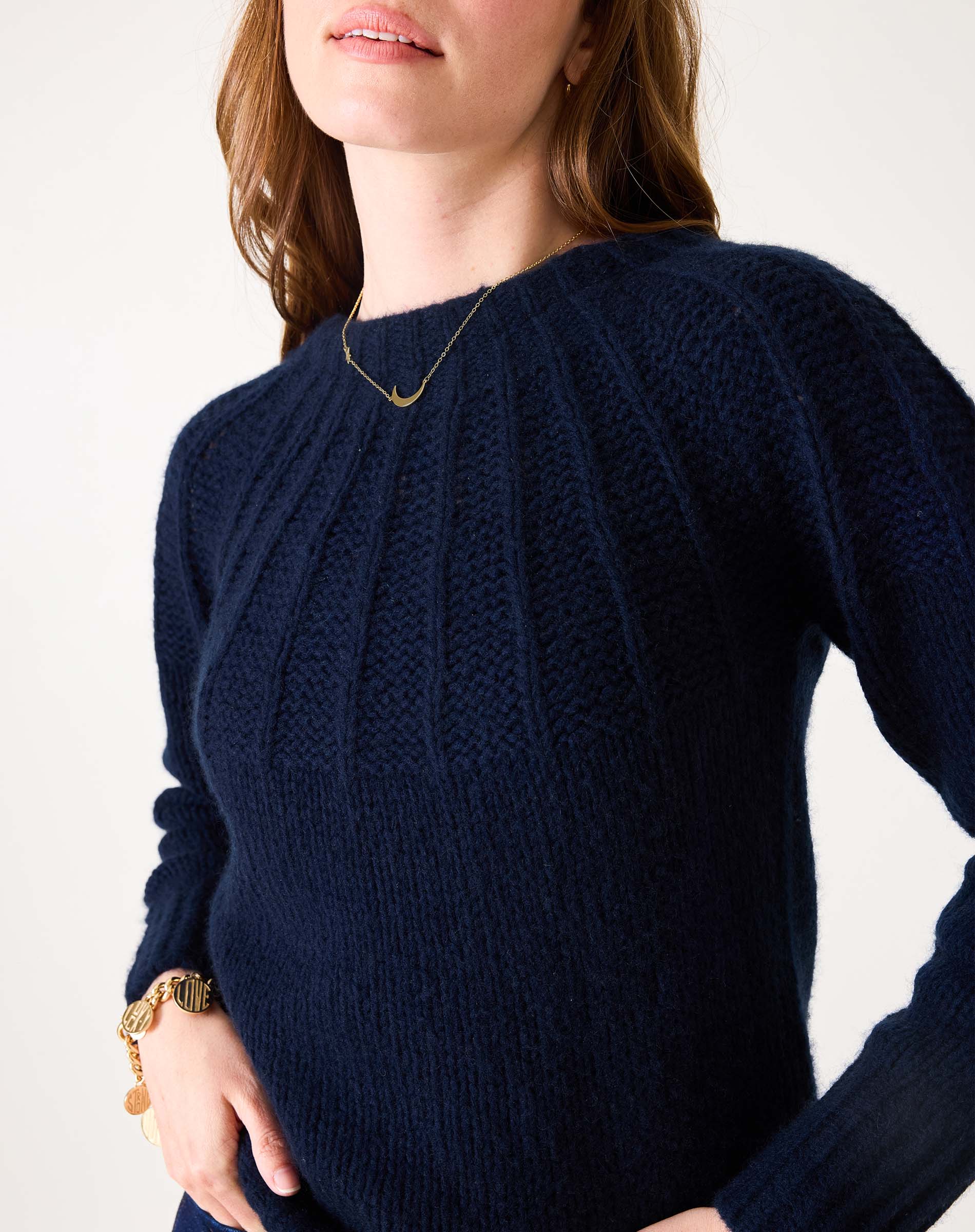 Navy blue ribbed knit sweater with a wide neckline and textured weave.