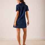 Back view of women's travel-friendly navy blue short sleeve denim-look dress with a button-up back.