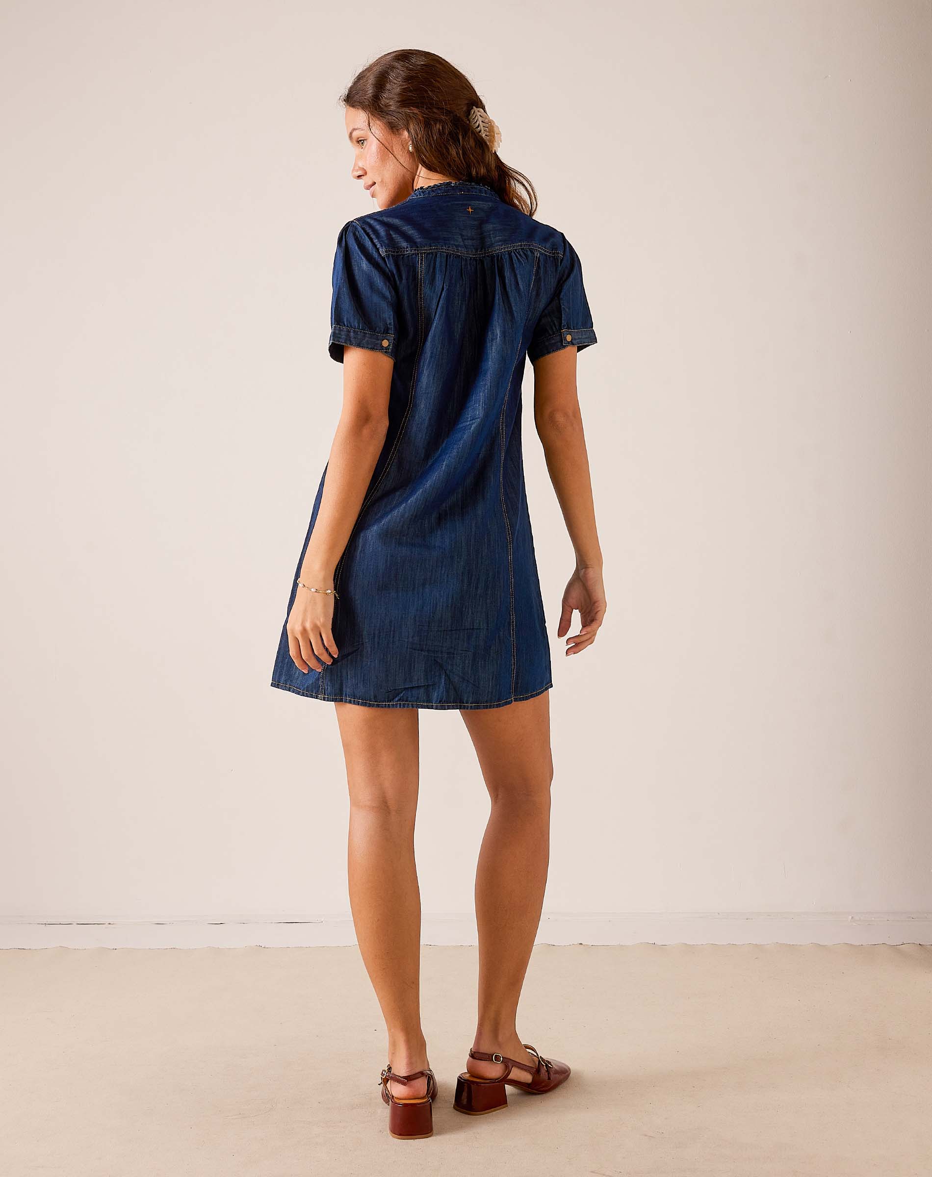 Back view of women's travel-friendly navy blue short sleeve denim-look dress with a button-up back.