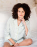woman sitting on bed wearing over the cotton moon nightshirt with hand under chin