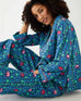 woman wearing matching pajama set with elephant garden print sitting on floor