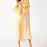 woman wearing tan and yellow maxi dress with embroidery