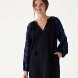 female upper torso wearing Mersea black embroidered maxi dress with V-neck and tassel ties on a white background