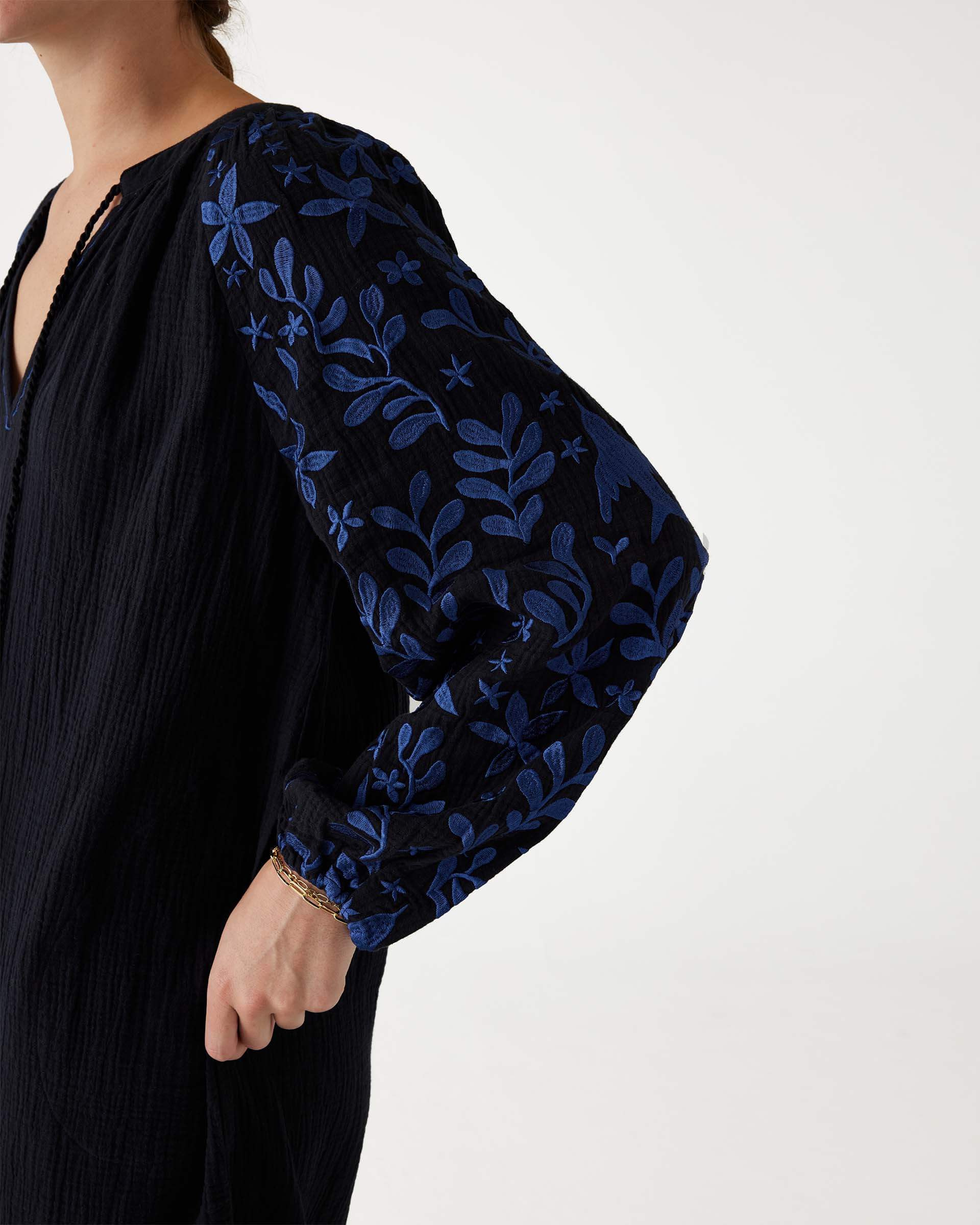 closeup of sleeve blue embroidery on black Mersea V-neck Palermo dress