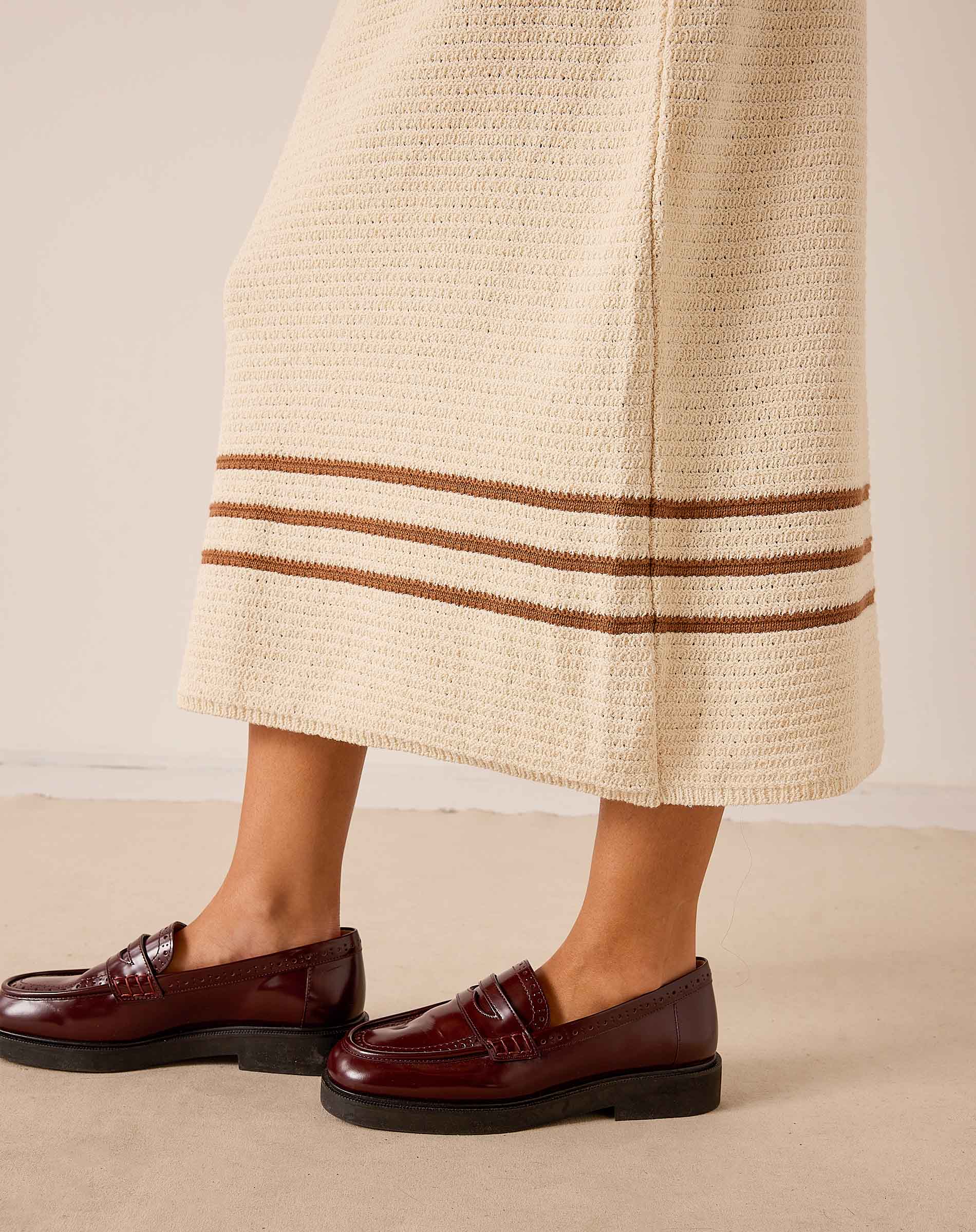 Ecru and almond crochet skirt featuring horizontal stripe detailing and a wide hem.