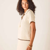 Woman wearing a beige textured outfit with a white background