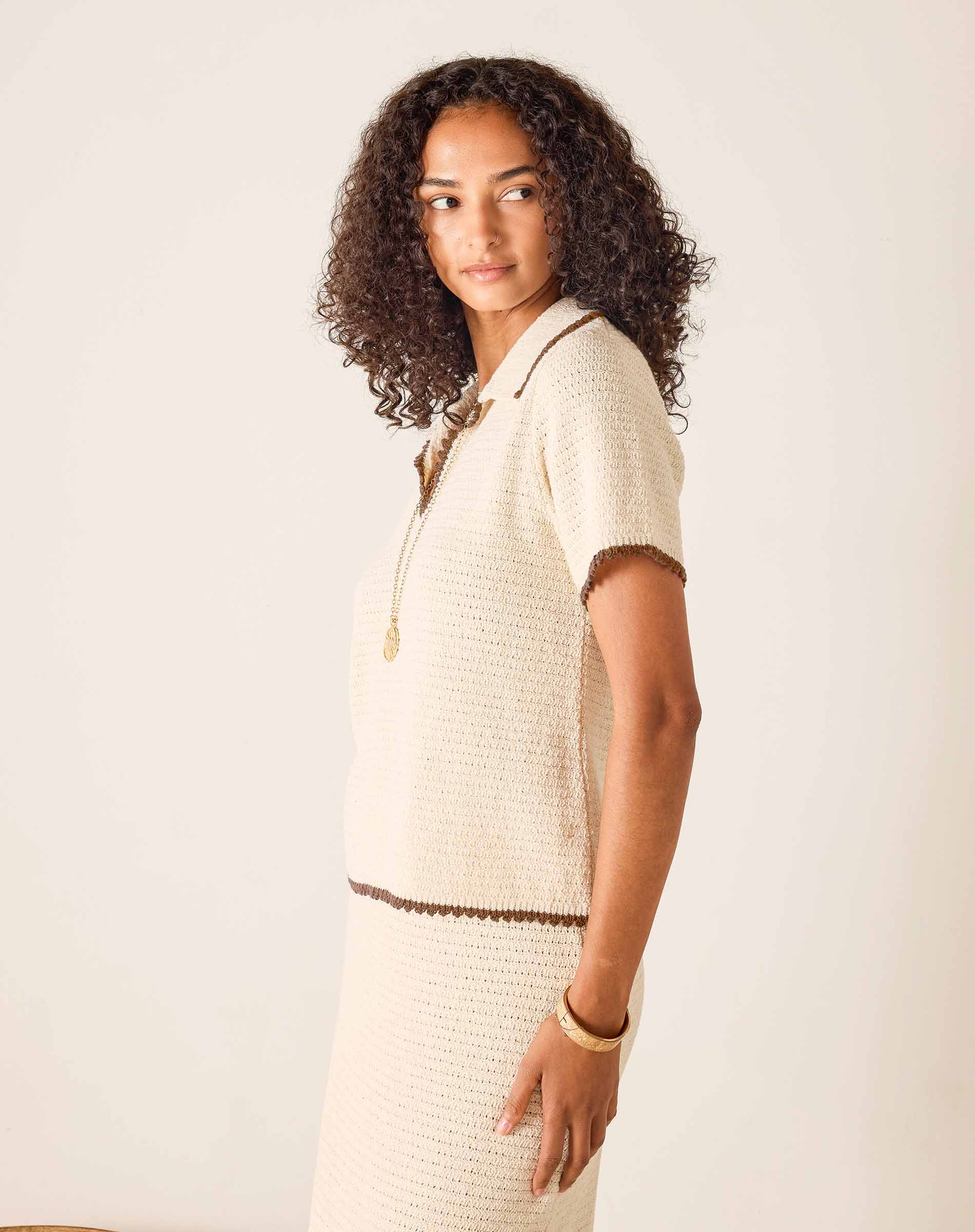 Woman wearing a beige textured outfit with a white background