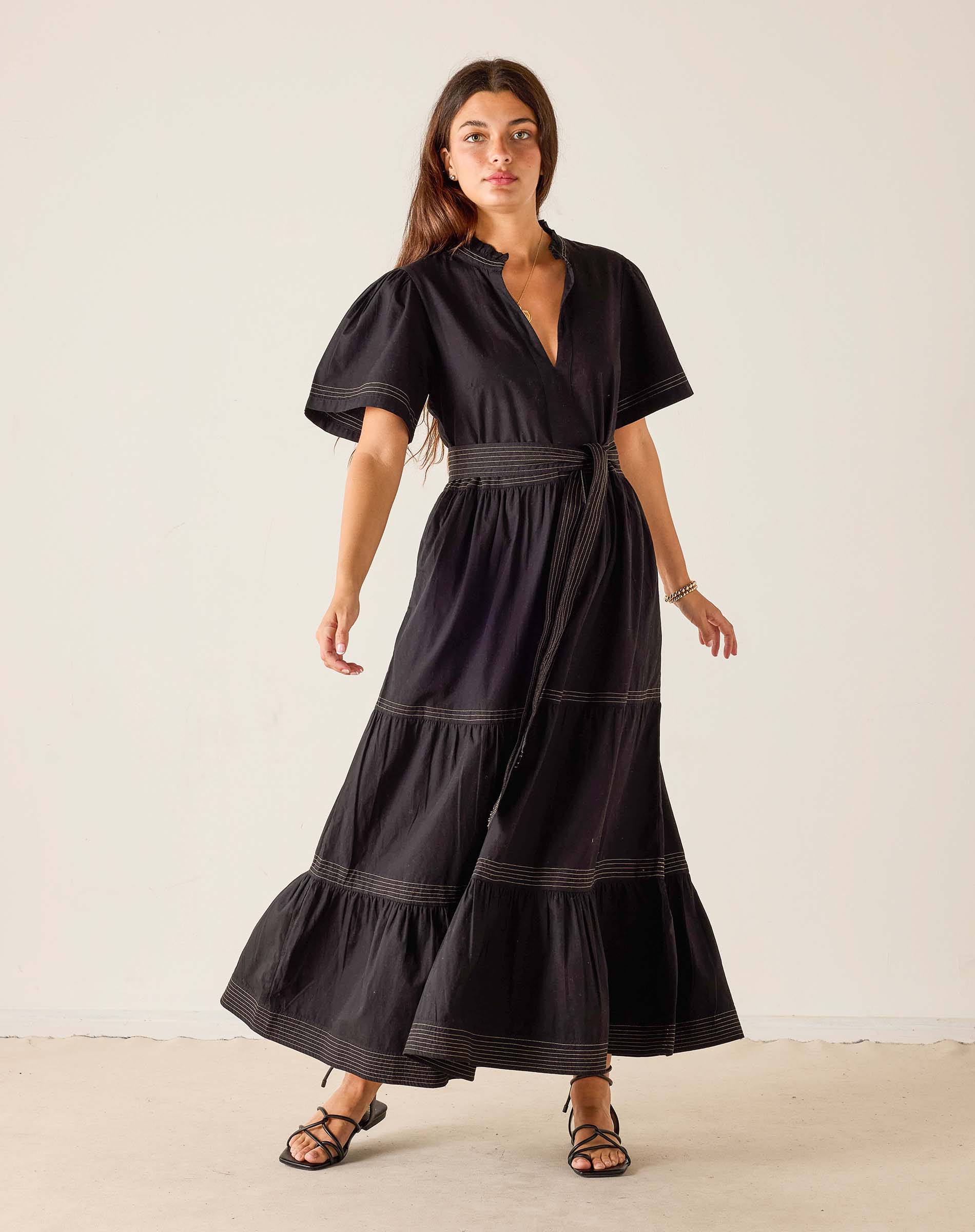 Woman wearing a black dress with puff sleeves against a white background