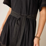 Black dress with white pinstripes on a neutral background