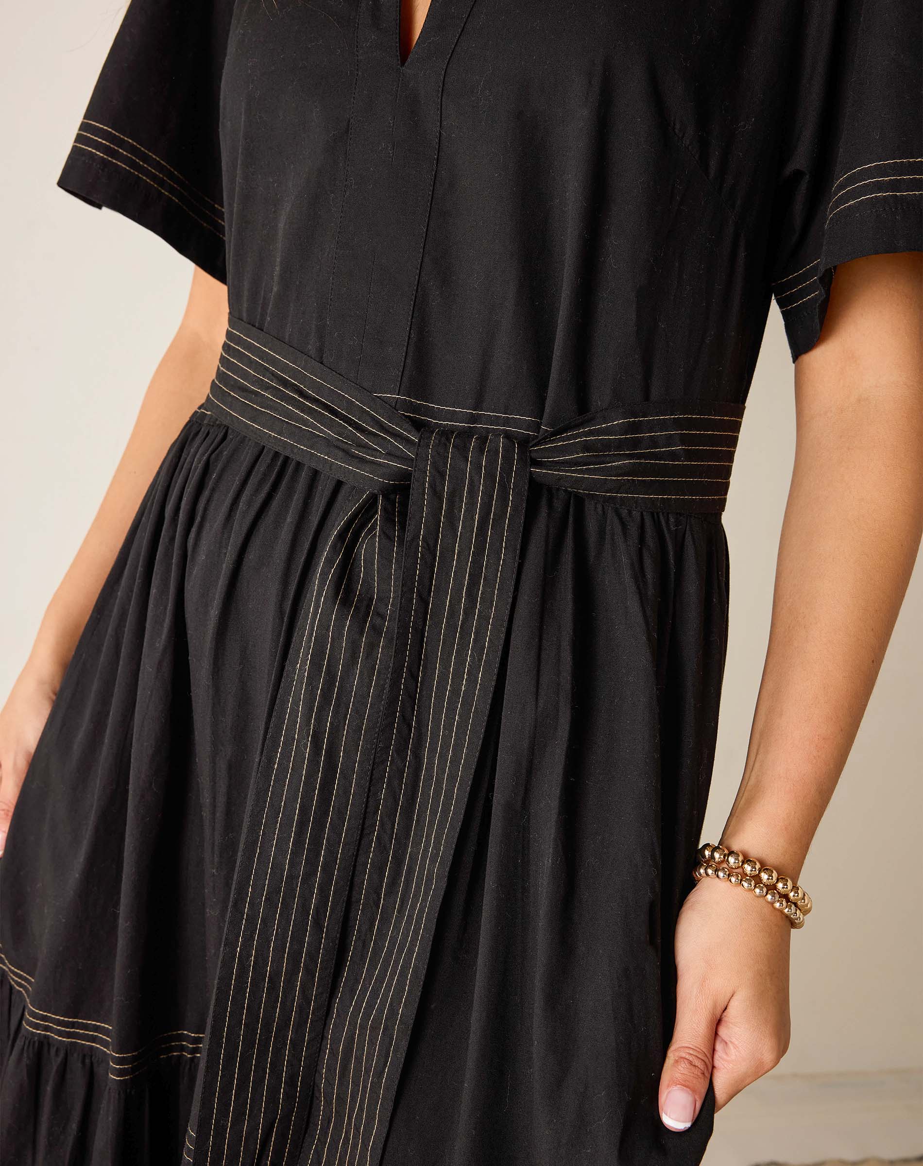 Black dress with white pinstripes on a neutral background