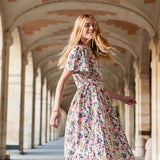 Woman in a floral dress walking through an archway