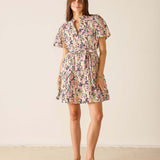 Woman wearing a floral dress against a plain background